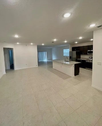 450 Hazel St, Sebastian, FL 32958 - kitchen with appliances with stainless steel finishes, recessed lighting, open floor plan, an island with sink, and dark cabinets