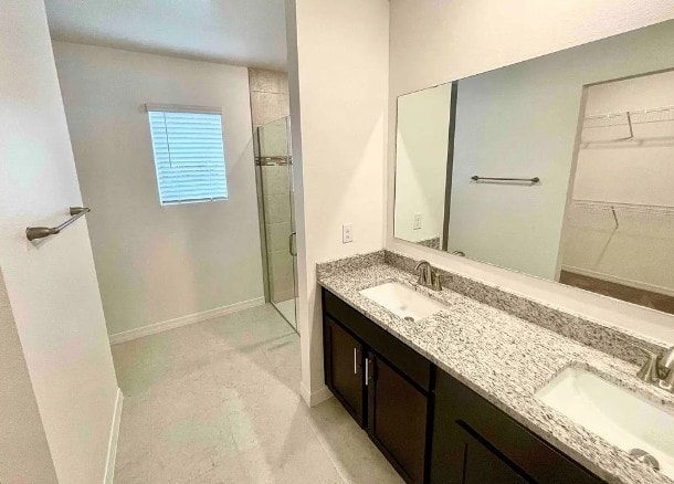 450 Hazel St, Sebastian, FL 32958 - bathroom featuring a tile shower, double vanity, and a spacious closet