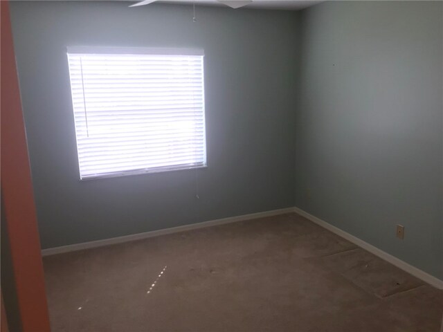 carpeted spare room with ceiling fan