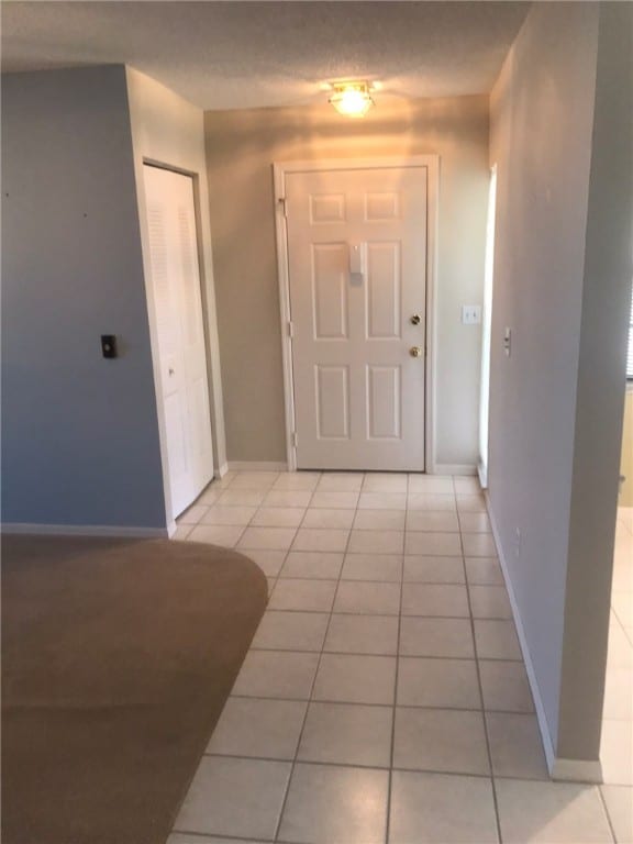 hall with light tile patterned floors