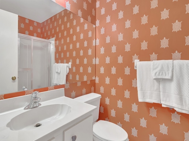 bathroom with vanity, toilet, and an enclosed shower