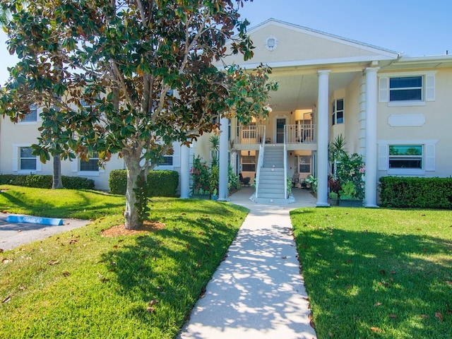 neoclassical / greek revival house featuring a front yard