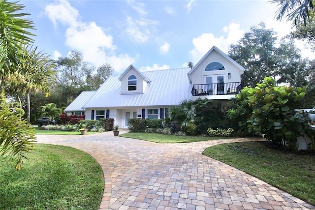 view of front of home with a balcony and a front lawn