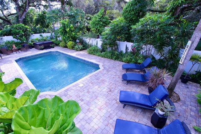 view of swimming pool featuring a patio area and a hot tub