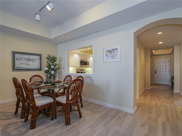 dining room featuring track lighting and light hardwood / wood-style flooring