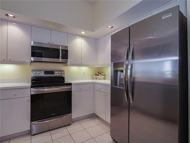 kitchen with white cabinetry, light tile patterned floors, and stainless steel appliances