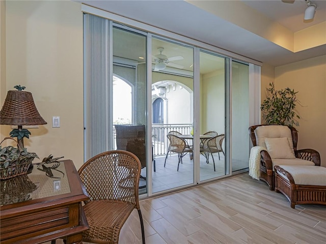 interior space featuring ceiling fan, light hardwood / wood-style floors, and a tray ceiling