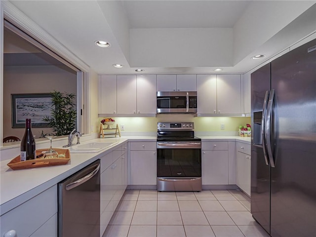 kitchen featuring light tile patterned floors, appliances with stainless steel finishes, white cabinets, and sink