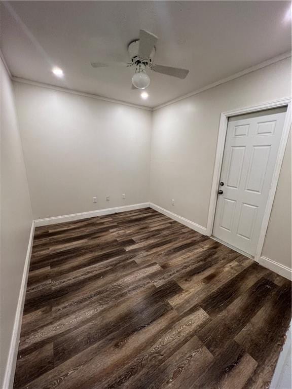 empty room with crown molding, baseboards, ceiling fan, and dark wood-type flooring
