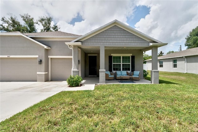 view of front of home featuring covered porch, a front lawn, a garage, and an outdoor living space