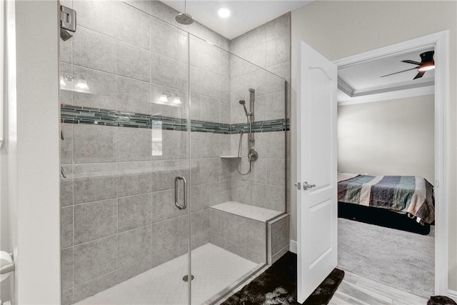 bathroom featuring a shower with door and ceiling fan