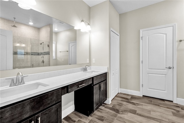 bathroom featuring hardwood / wood-style flooring, vanity, and a shower with door