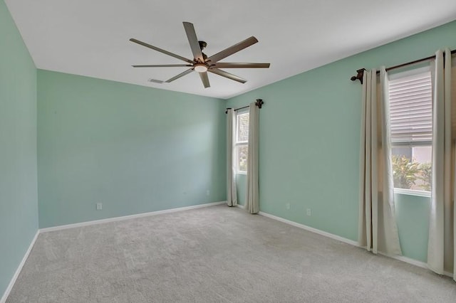 carpeted empty room featuring baseboards and ceiling fan