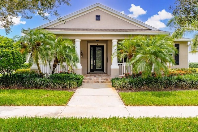 property entrance featuring covered porch and stucco siding