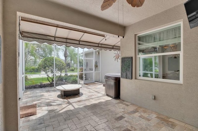 unfurnished sunroom with ceiling fan