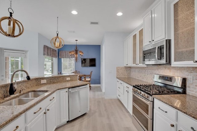 kitchen featuring visible vents, an inviting chandelier, a sink, appliances with stainless steel finishes, and tasteful backsplash