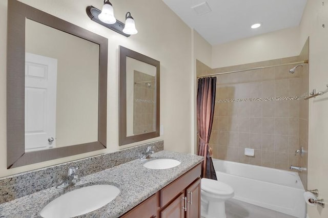 full bathroom with double vanity, toilet, shower / bath combo with shower curtain, and a sink