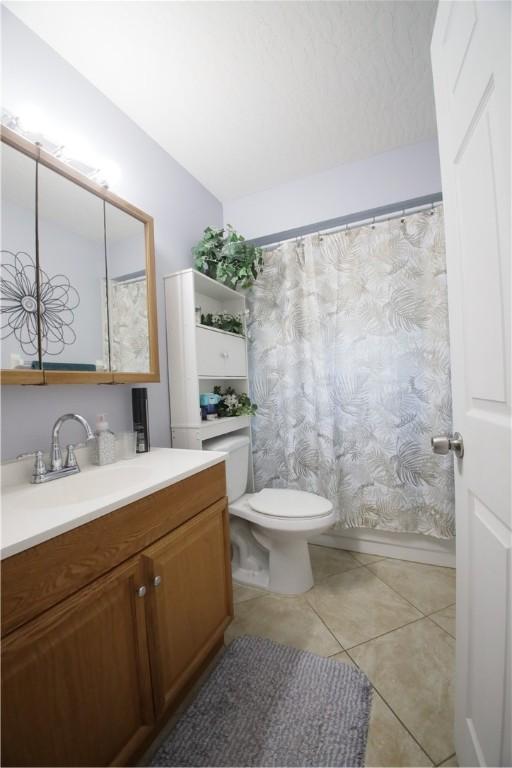 bedroom with light tile patterned floors, a closet, and ceiling fan