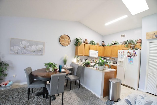 kitchen featuring visible vents, white appliances, a peninsula, light countertops, and lofted ceiling