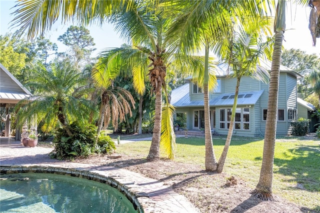 view of swimming pool with a lawn