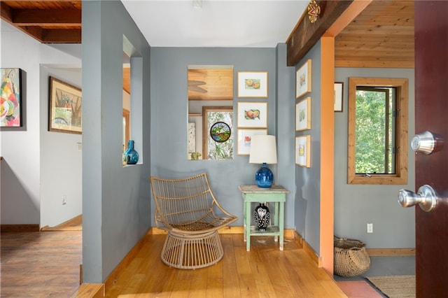 living area with light wood-type flooring and wood ceiling