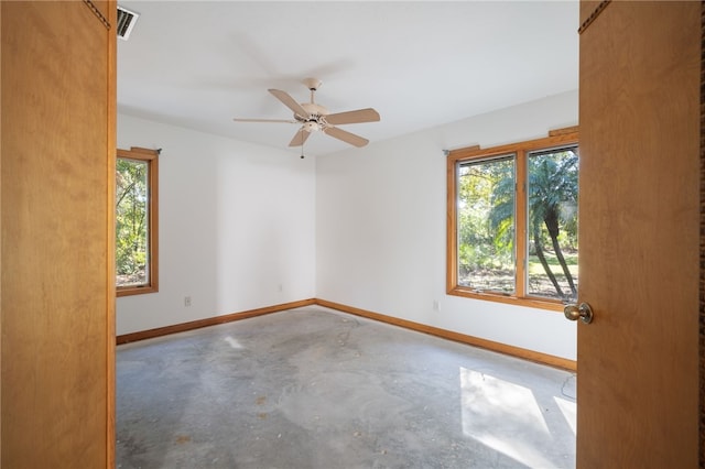 empty room with ceiling fan and concrete flooring