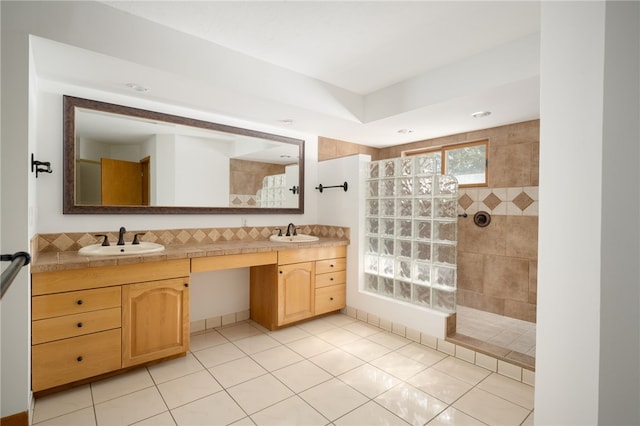 bathroom featuring tile patterned floors, vanity, and a tile shower