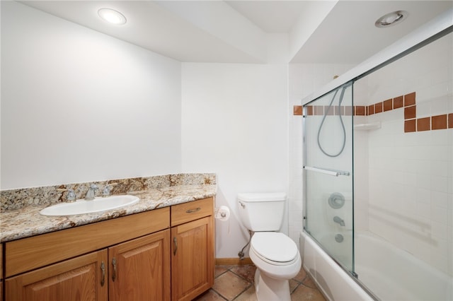 full bathroom featuring shower / bath combination with glass door, tile patterned floors, vanity, and toilet