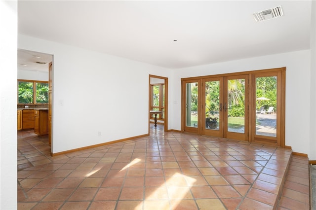 tiled spare room with french doors