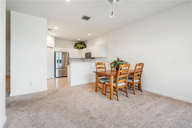 dining area featuring ceiling fan and light carpet