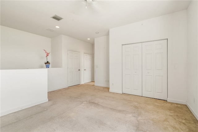 unfurnished bedroom featuring light carpet