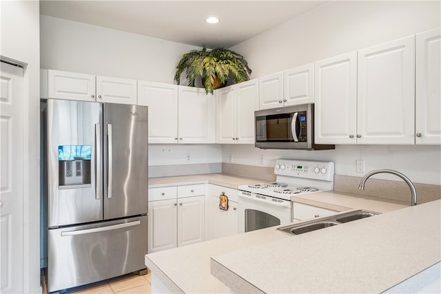 kitchen featuring appliances with stainless steel finishes, light tile patterned floors, and white cabinetry