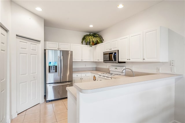 kitchen with white cabinets, light tile patterned floors, stainless steel appliances, and kitchen peninsula