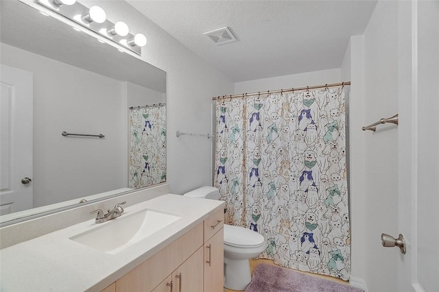 bathroom featuring vanity, a textured ceiling, and toilet