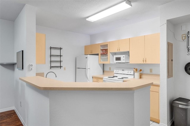 kitchen with sink, white appliances, kitchen peninsula, light brown cabinets, and a textured ceiling