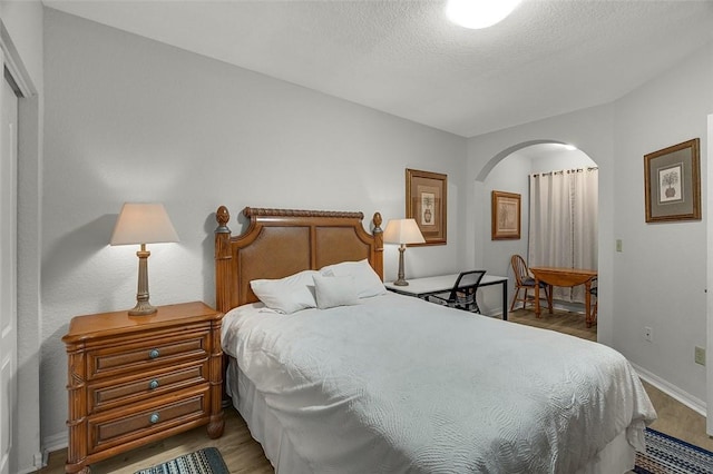 bedroom featuring hardwood / wood-style floors and a textured ceiling