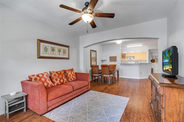 living room with ceiling fan and dark hardwood / wood-style floors