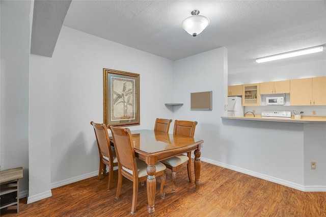 dining area featuring hardwood / wood-style floors and a textured ceiling