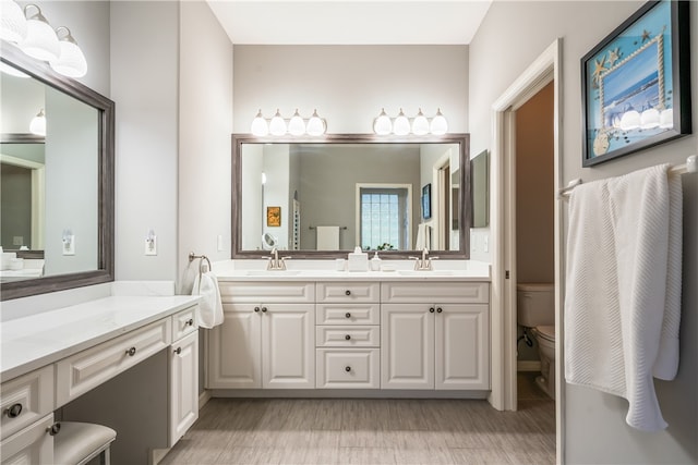 bathroom with vanity, hardwood / wood-style flooring, and toilet