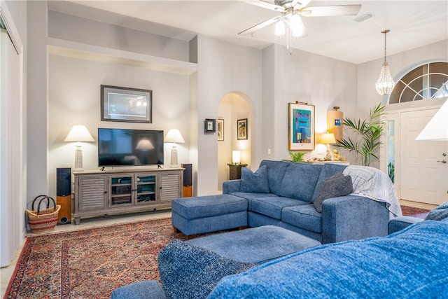 living room featuring ceiling fan and a towering ceiling