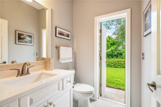 bathroom with toilet, vanity, and tile patterned floors