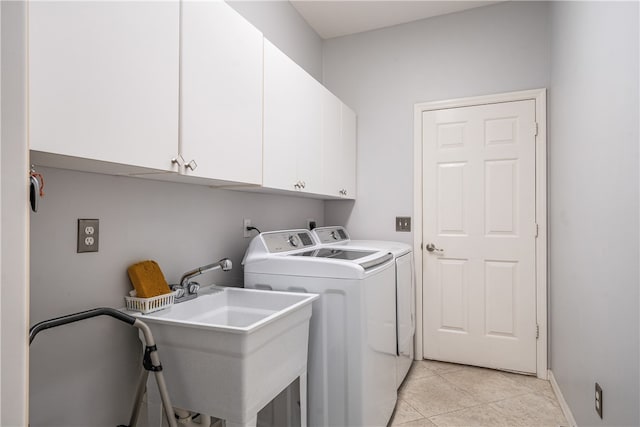 laundry room featuring washing machine and dryer, cabinets, sink, and light tile patterned floors