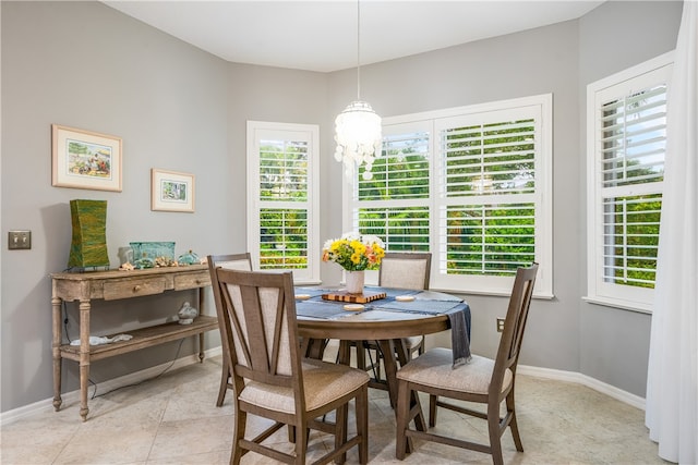 tiled dining room featuring a notable chandelier