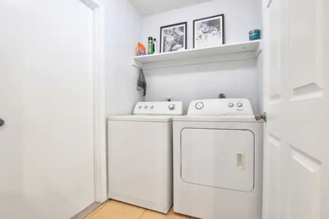 clothes washing area with light tile patterned floors, laundry area, and independent washer and dryer