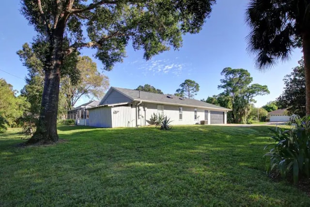 view of side of home featuring a yard and a garage