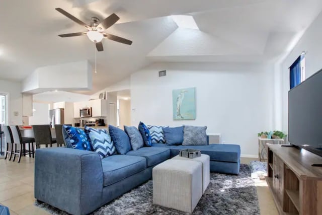 living area with visible vents, baseboards, a ceiling fan, and vaulted ceiling