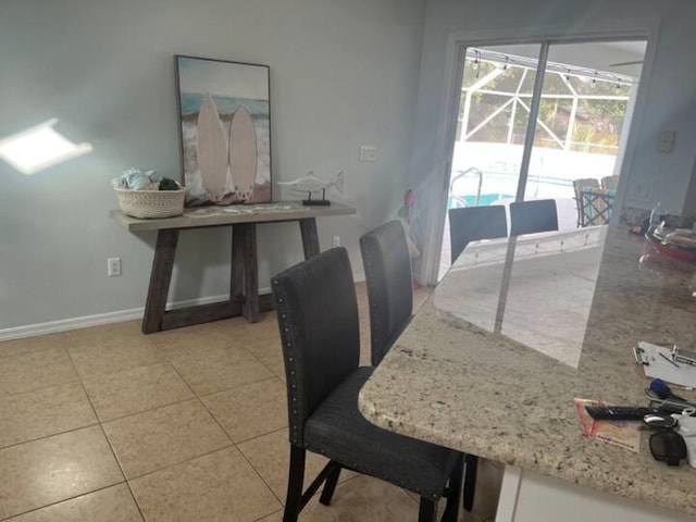 dining area featuring light tile patterned floors and baseboards