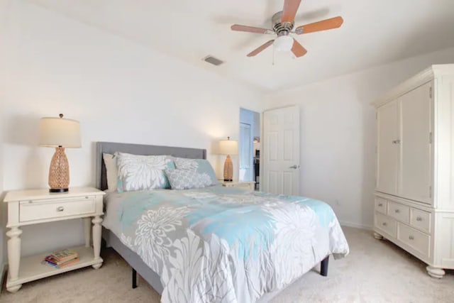 bedroom with visible vents, light colored carpet, a ceiling fan, and baseboards