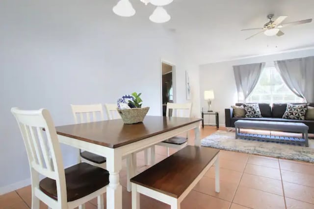 dining room featuring tile patterned floors, ceiling fan with notable chandelier, and baseboards