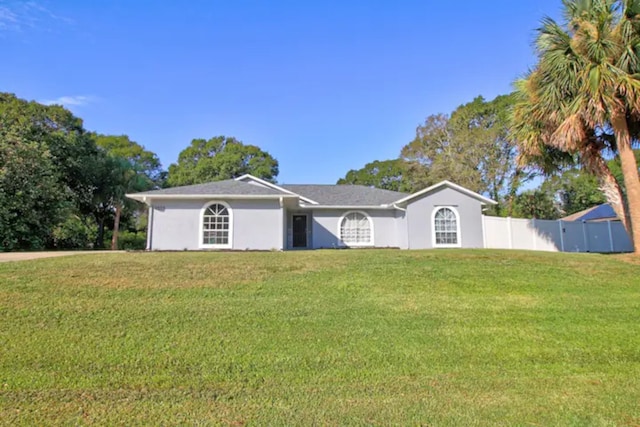 ranch-style house featuring stucco siding, a front yard, and fence